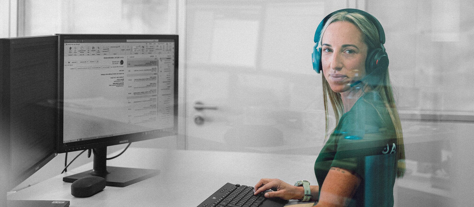 Image of a blonde woman with a headset at the computer, who answers incoming calls as an employee in the Rommelag call center.